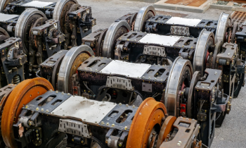 Several bogies (wheel assemblies) of rail vehicles, lined up outdoors